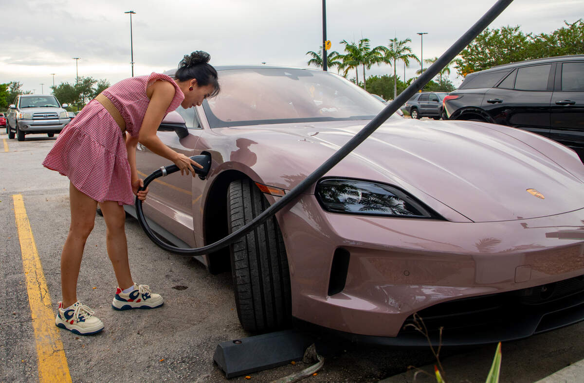 Tang P. plugs her pink Porsche Taycan into an electric vehicle charging port in the Walmart parking lot in Hialeah on Friday, Sep. 24. Tang had two cars ahead of her in line waiting to use one of the five pumps.